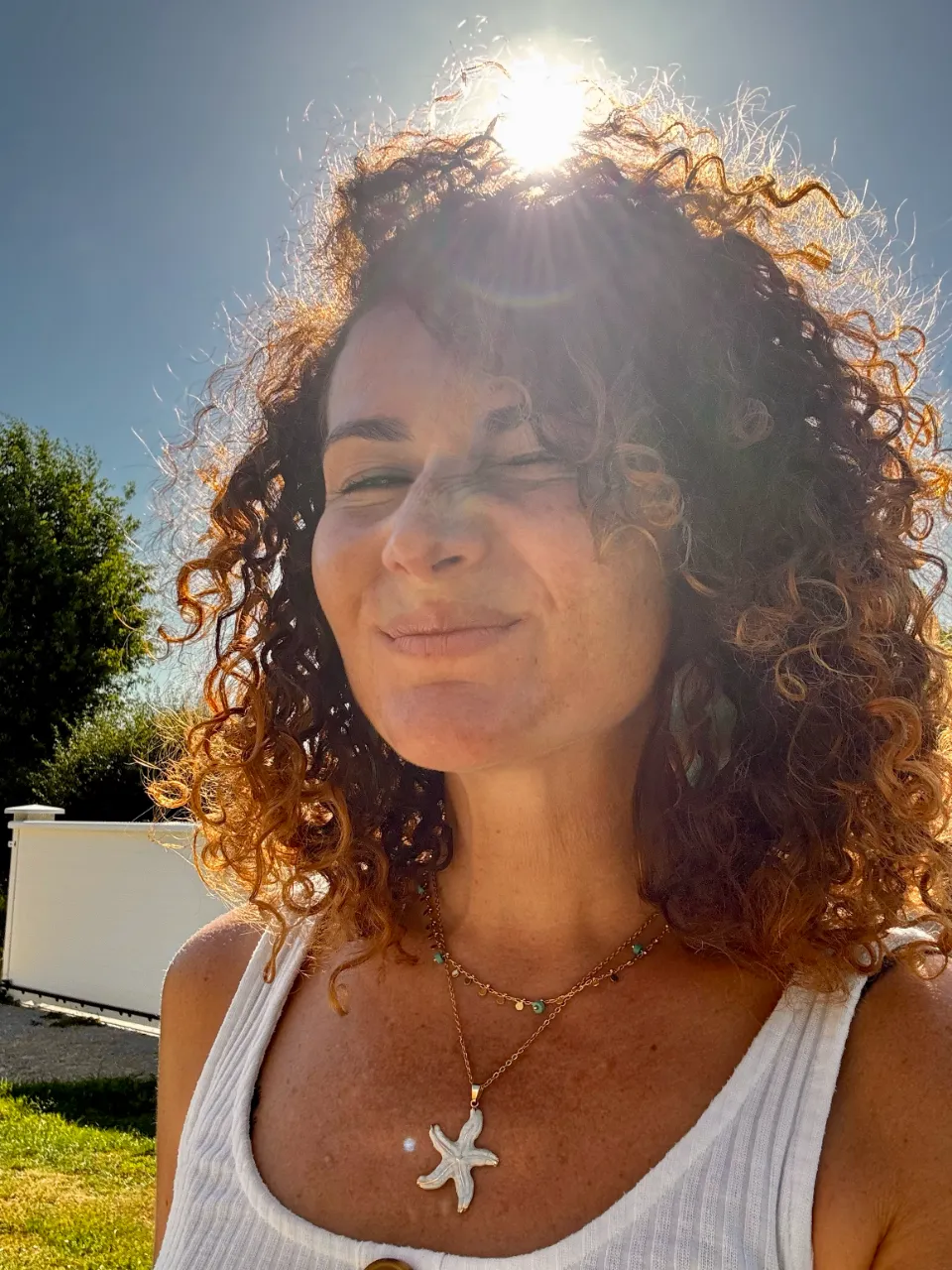 femme-souriante-au-soleil-avec-collier-etoile-de-mer | Chloé Lance Deisgns
